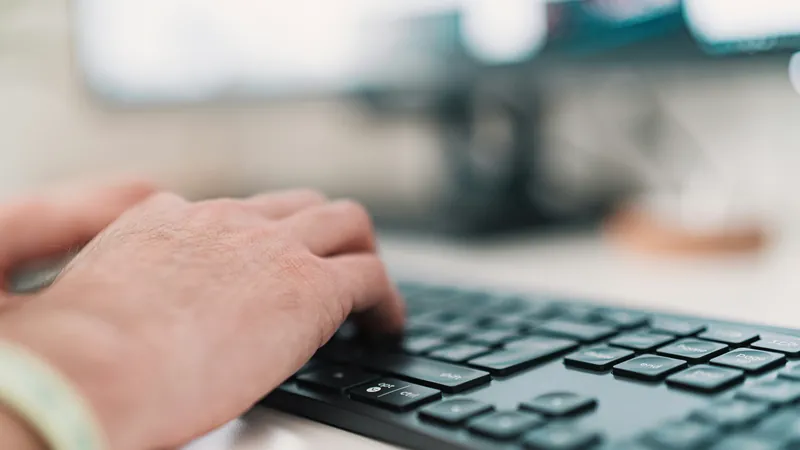 Hände tippen auf einer Laptop-Tastatur — KI und Rechtskonformität für Kanzleien